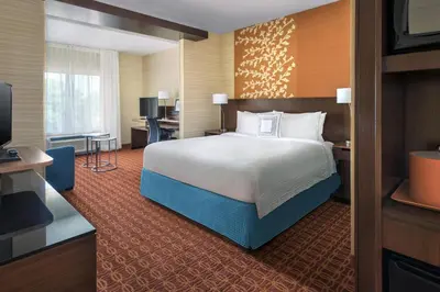 a hotel room with a bed and a television at Fairfield Inn & Suites by Marriott New Castle in New Castle