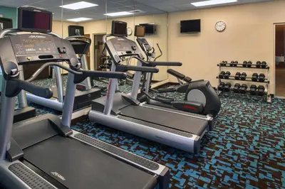 a gym with several tread machines and a clock at Fairfield Inn & Suites by Marriott New Castle in New Castle