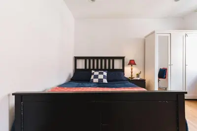 a bed with a black frame in a bedroom at East Village Townhouse in New York