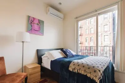 a bedroom with a bed and a window at East Village Townhouse in New York