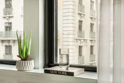 a glass on a window sill with a new york sign at 73-1004 New Studio UWS Doorman Gym in New York