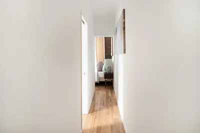 a hallway leading to a living room with white walls at 153-1G Newly Renovated 2BR Lower East Side in New York