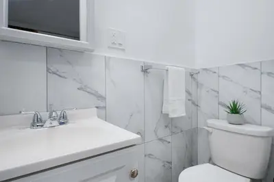 a white bathroom with a toilet and a sink at 153-1G Newly Renovated 2BR Lower East Side in New York
