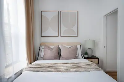 a bedroom with a bed with three pictures on the wall at 153-1G Newly Renovated 2BR Lower East Side in New York