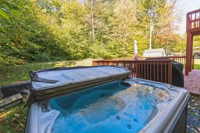 a hot tub with a cover on top of it at Horatio Hideaway Pocono Escape in Tobyhanna