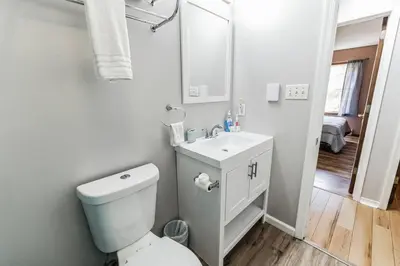 a white bathroom with a toilet and a sink at Horatio Hideaway Pocono Escape in Tobyhanna