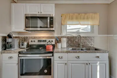 a kitchen with a stove and a sink and a microwave at Cozy Pennsylvania Home with Fire Pit and Dock Access! in Carbondale