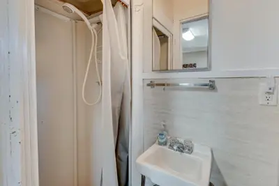 a white bathroom with a sink and a mirror at Cozy Pennsylvania Home with Fire Pit and Dock Access! in Carbondale