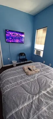 a bedroom with a large bed with a tv on the wall at willoughby inn in Newark