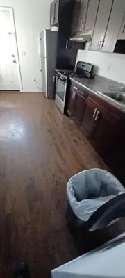 a kitchen with a trash can in the middle of a room at willoughby inn in Newark