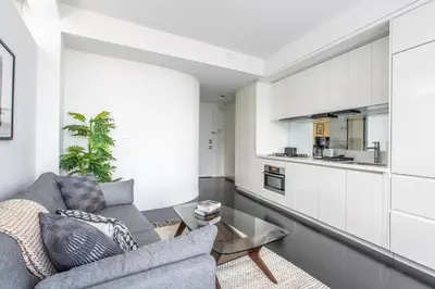 a living room with a couch and a kitchen at Financial District 1br w WD gym elevator NYC-1360 in New York