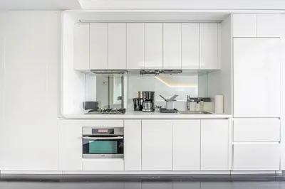 a white kitchen with white cabinets and appliances at Financial District 1br w WD gym elevator NYC-1360 in New York