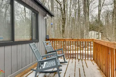 two chairs sitting on the porch of a house at Pocono Pines Home with Private Hot Tub! in Pocono Pines