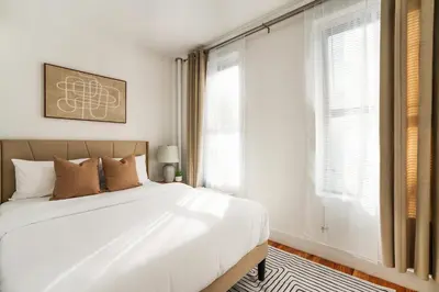 a bedroom with a large white bed and a window at 444-2E Modern 2BR Hell's Kitchen in New York