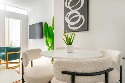 a dining room with a white table and chairs at 444-2E Modern 2BR Hell's Kitchen in New York