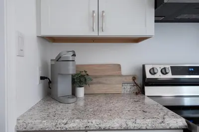a kitchen with white cabinets and a counter top at The Wren's Nest in Birdsboro