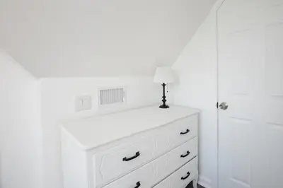 a white dresser with a lamp on top of it at The Wren's Nest in Birdsboro