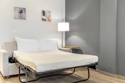 a hospital bed in a room next to a chair at Comfort Inn & Suites Newark Liberty International Airport in Newark
