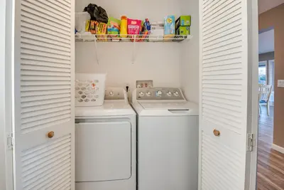 a small kitchen with white cabinets and a washer and dryer at Family Home on Lake Newton with Deck and Fire Pit in Carbondale
