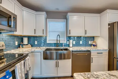 a kitchen with white cabinets and a stainless steel sink at Family Home on Lake Newton with Deck and Fire Pit in Carbondale