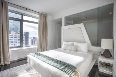 a bedroom with a large bed and a large window at Financial District 1br w WD gym elevator NYC-1378 in New York