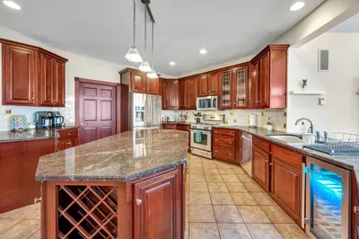 a large kitchen with wooden cabinets and granite counter tops at Poconos Playtime Paradise Luxury Play Escape in Pocono Pines