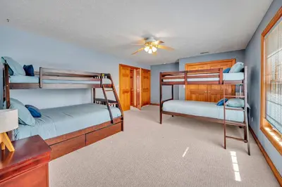 a bedroom with two bunk beds and a ceiling fan at Poconos Playtime Paradise Luxury Play Escape in Pocono Pines