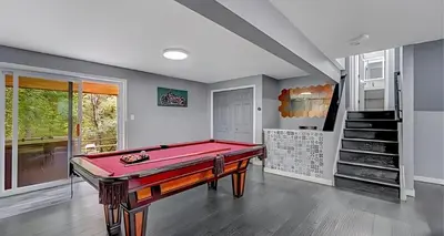 a pool table in a room with a staircase at Peaceful Pocono Home with Hot Tub, gym, & office in Long Pond