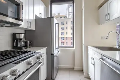 a kitchen with a stainless steel refrigerator and a window at Upper West Side 2br w rooftop gym nr park NYC-1216 in New York