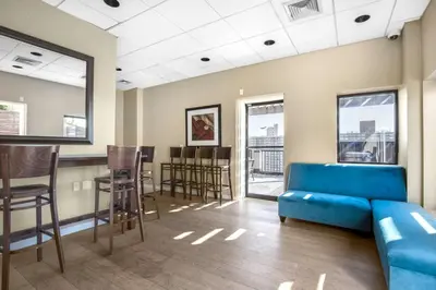 a waiting room with a blue couch and a bar at Upper West Side 2br w rooftop gym nr park NYC-1216 in New York