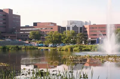a pond with a fountain in the middle of a city at Spacious Apt near Guthrie Packer in Sayre