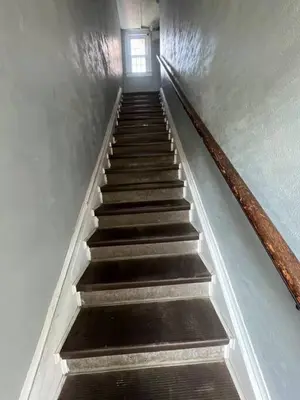 a stairway leading up to a window in a building at Spacious Apt near Guthrie Packer in Sayre