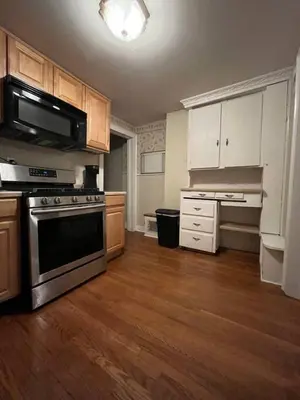 a kitchen with wooden floors and a stove and cabinets at Intimate 1 Bedroom Apt by UHS in Binghamton