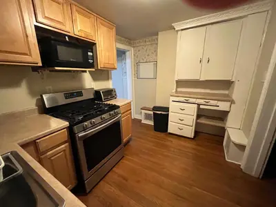 a kitchen with wooden cabinets and a stove top oven at Intimate 1 Bedroom Apt by UHS in Binghamton