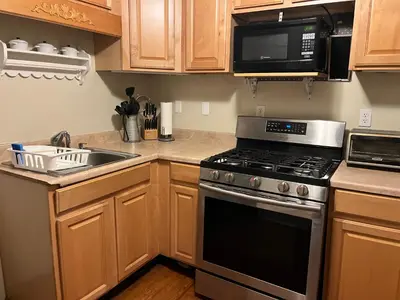 a kitchen with a stove and a sink and a microwave at Intimate 1 Bedroom Apt by UHS in Binghamton