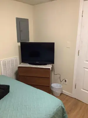 a bedroom with a flat screen tv and a bed at Cozy Apt near BU, Lourdes, UHS in Johnson City
