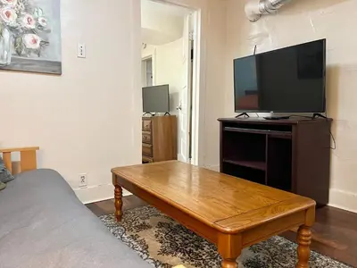 a living room with a television and a wooden coffee table at Cheerful Studio short walk to UHS near Lourdes & BU in Johnson City