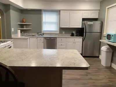 a kitchen with white cabinets and a stainless steel refrigerator at Spacious Inviting Home by BU UHS & Guthrie in Johnson City