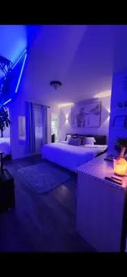 a bedroom with a large bed with purple lighting at Zen Oasis Room in Newark