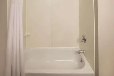 a white bath tub with a shower curtain in a bathroom at La Quinta by Wyndham Mechanicsburg - Harrisburg in Mechanicsburg