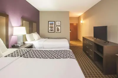 a hotel room with two beds and a flat screen tv at La Quinta by Wyndham Mechanicsburg - Harrisburg in Mechanicsburg