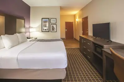 a hotel room with a bed and a flat screen tv at La Quinta by Wyndham Mechanicsburg - Harrisburg in Mechanicsburg