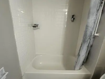 a white bathroom with a tub and a shower at THE GOLFERS INN in Upper Darby