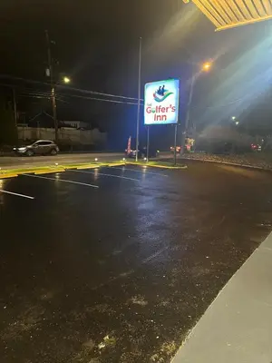 a lit up sign on a street at night at THE GOLFERS INN in Upper Darby