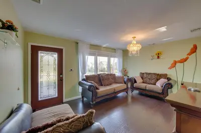 a living room with two couches and a chandelier at 2 Mi to Hersheypark Group Getaway with Deck in Hummelstown