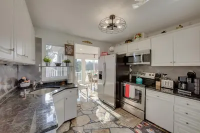 a kitchen with white cabinets and a stainless steel refrigerator at 2 Mi to Hersheypark Group Getaway with Deck in Hummelstown