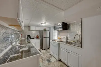 a kitchen with white cabinets and a stainless steel refrigerator at 2 Mi to Hersheypark Group Getaway with Deck in Hummelstown