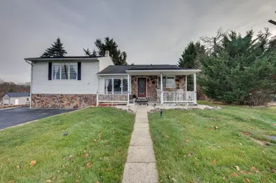 a white house with a porch and a yard at 2 Mi to Hersheypark Group Getaway with Deck in Hummelstown