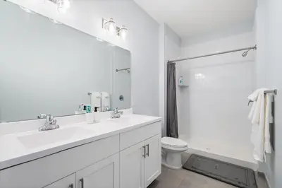a white bathroom with a sink and a toilet at Modern 2BR 2BA Condo Sleeps 8 with Gym Laundry 20 Min to NYC in Jersey City