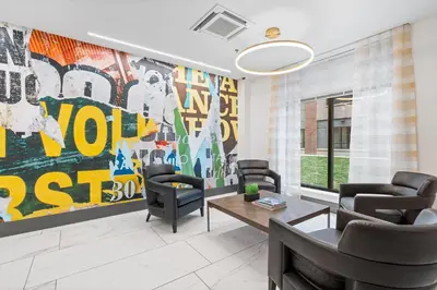 a living room with a large painting on the wall at Modern 2BR 2BA Condo Sleeps 8 with Gym Laundry 20 Min to NYC in Jersey City